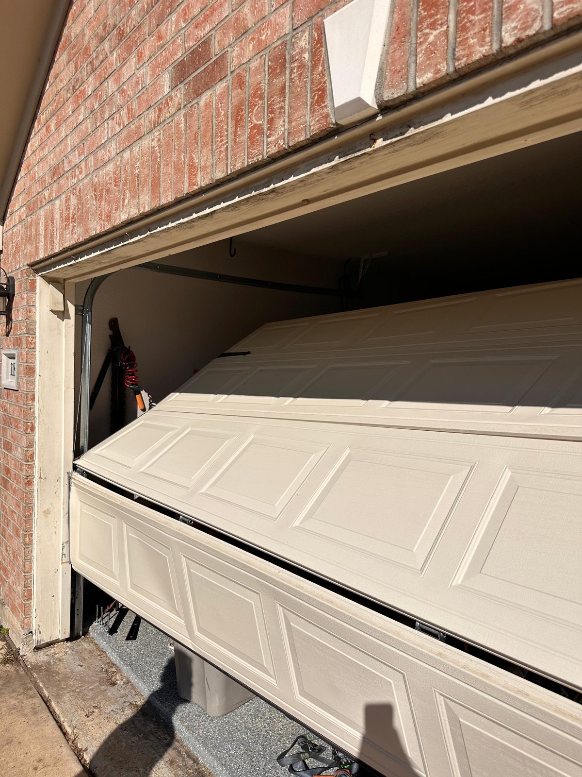 Dented garage door panel before replacement by TikTak in Houston