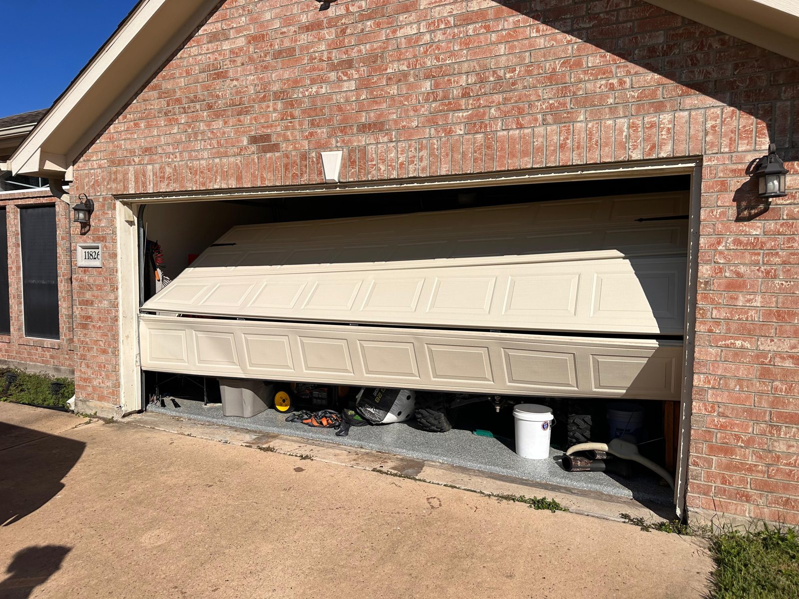 Garage door off its track being reset by a TikTak technician in Houston