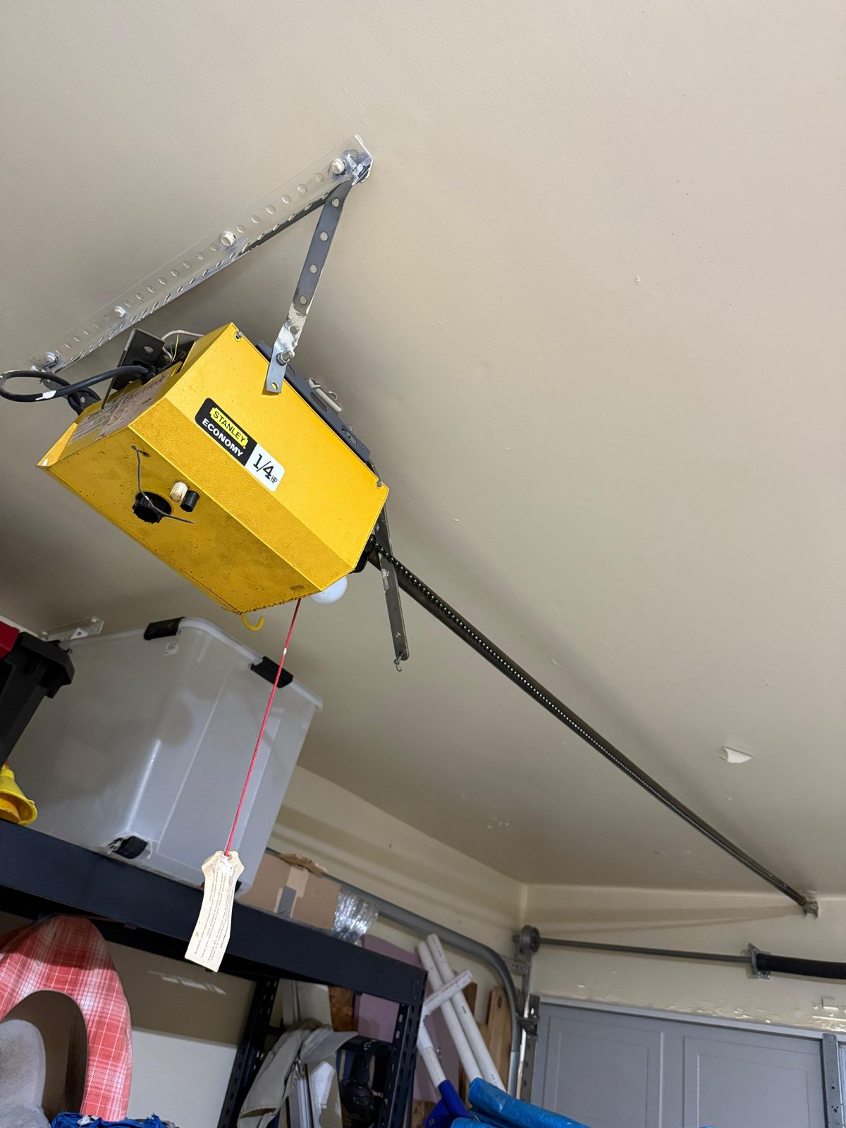 TikTak technician servicing a garage door opener motor in Houston